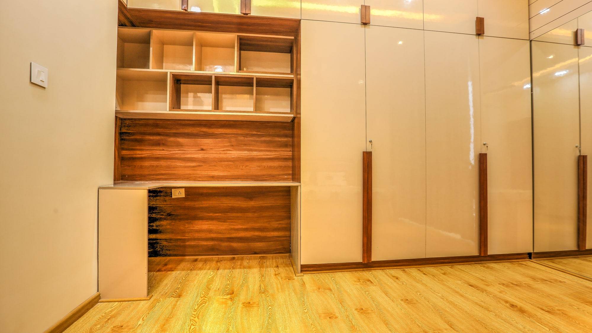 Bedroom study station with warm wood desk and ivory gloss wardrobes