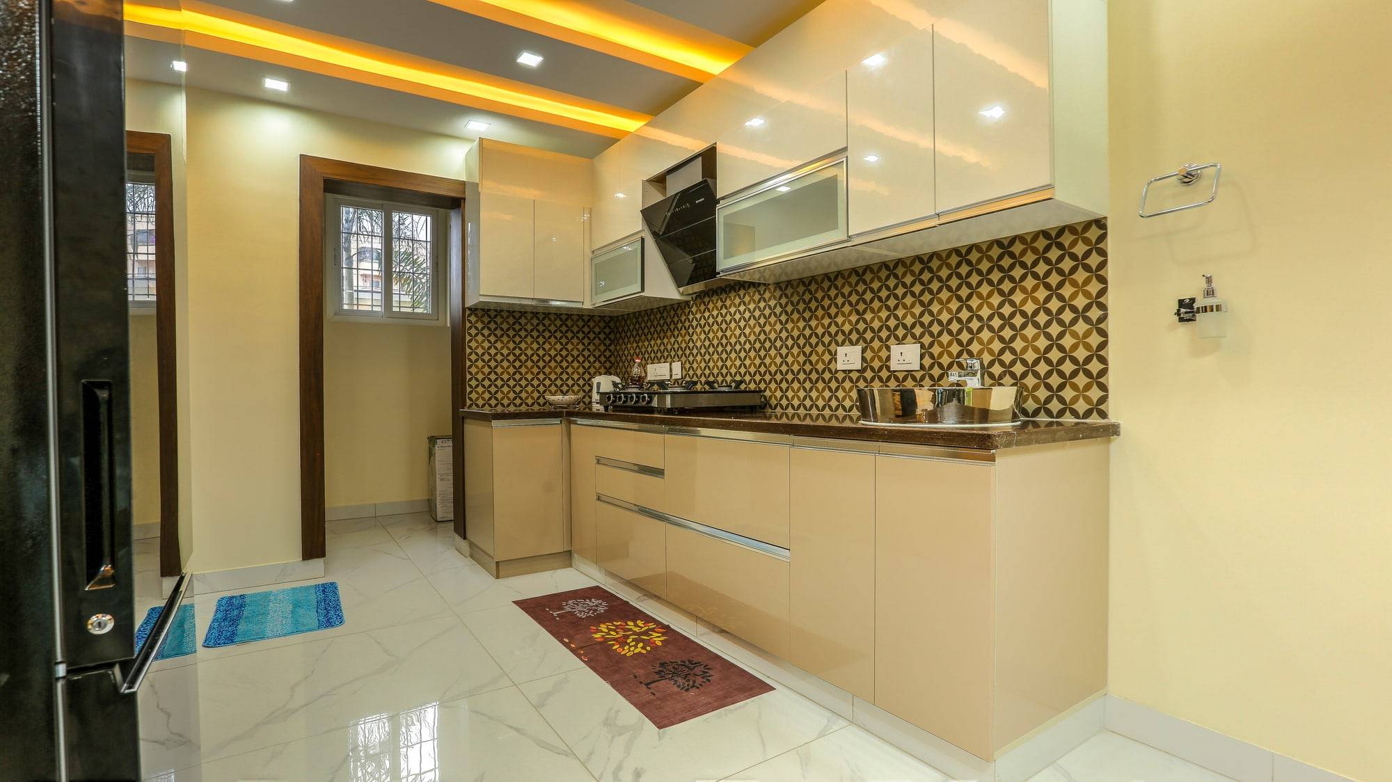Kitchen counter with glossy cappuccino cabinets and geometric backsplash