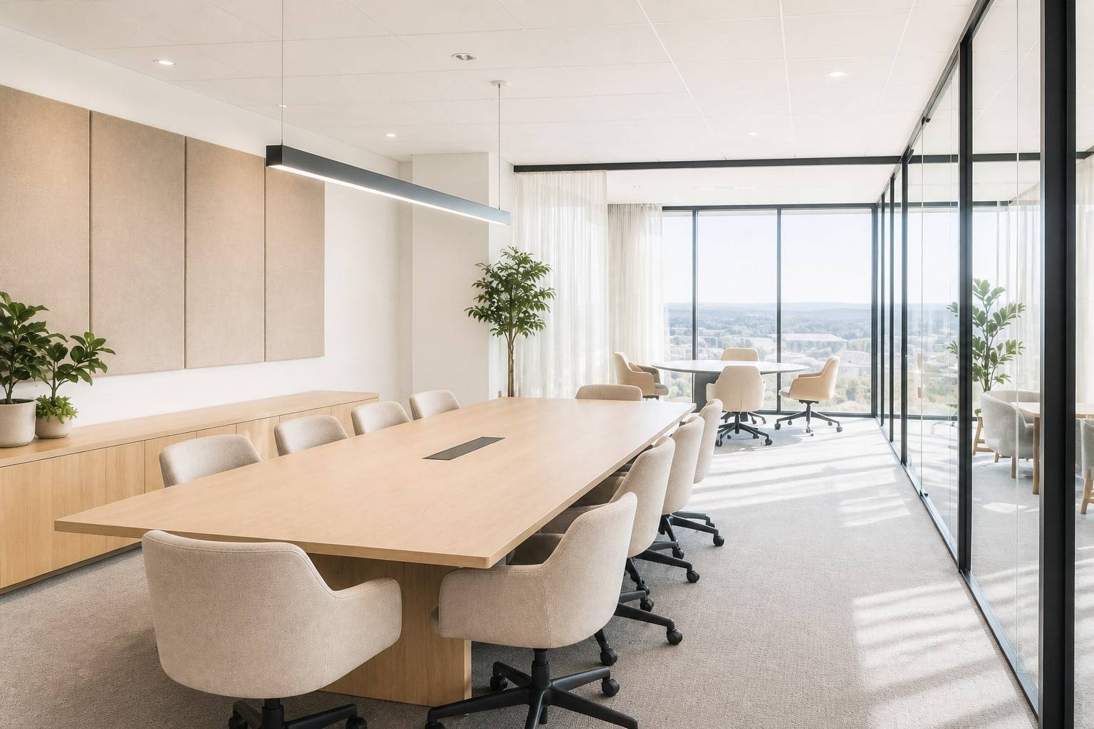 Bright conference room with a pale oak table, cream chairs, and glass partitions